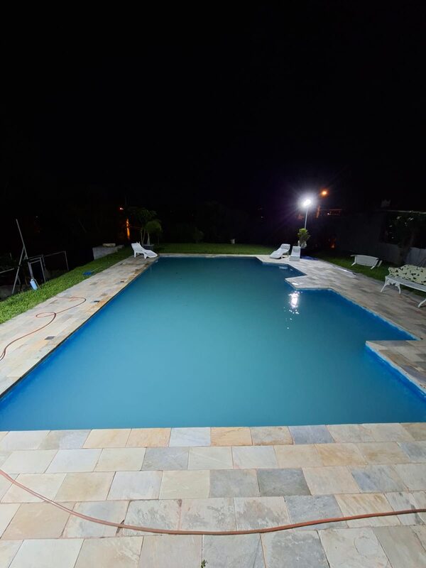 Piscina com água turva e esbranquiçada, à noite