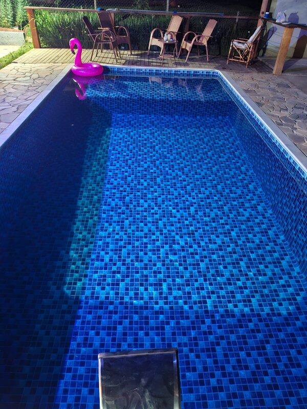 Piscina de pastilha azul escura com cascata de inox